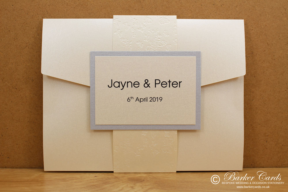 contemporary_pocketfold_wedding_invitations_in_ivory_cream_and_silver_with_band_and_ribbon_01