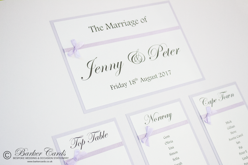 Personalised wedding table plan in white with lilac ribbon tied in small bows